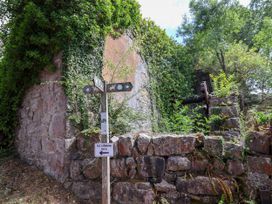 An outdoor area with a signpost and stone wall at The Lambing Shed Dyserth near Prestatyn