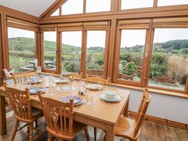 A dining room with a wooden table set for a meal at Lough Cluhir Cottage in Union Hall, County Cork