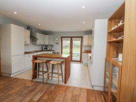 A kitchen with an island and bar stools at Lough Cluhir Cottage, Union Hall, County Cork