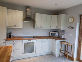 A kitchen with cabinets and appliances at Lough Cluhir Cottage in Union Hall, County Cork