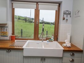 A kitchen with a sink and window at Lough Cluhir Cottage in Union Hall, County Cork