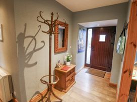 A hallway with a coat rack and a small table at Lough Cluhir Cottage, Union Hall, County Cork