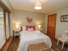 A bedroom with a bed and side tables at Lough Cluhir Cottage, Union Hall, County Cork