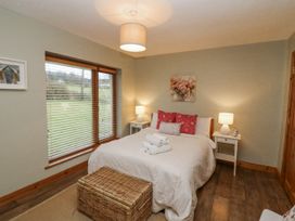 A bedroom with a bed and nightstands at Lough Cluhir Cottage, Union Hall, County Cork