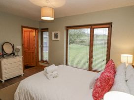 A bedroom with a bed and dresser at Lough Cluhir Cottage, Union Hall, County Cork