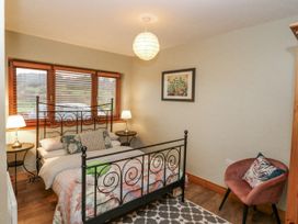 A bedroom with a bed and side tables at Lough Cluhir Cottage in Union Hall, County Cork