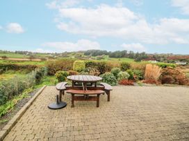 A garden with a picnic table and benches at Lough Cluhir Cottage in Union Hall, County Cork