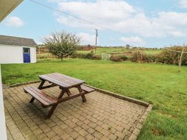 A garden with a picnic table and shed at Lough Cluhir Cottage, Union Hall, County Cork