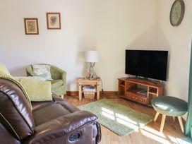 A living room with a tv and sofa at Lily Cottage in Caeathro near Caernarfon