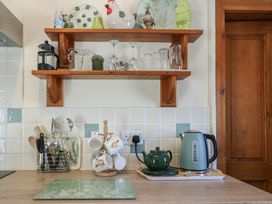A kitchen with shelf and utensils at Lily Cottage Caeathro near Caernarfon