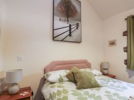 A bedroom with a bed and bedside table at Lily Cottage in Caeathro near Caernarfon