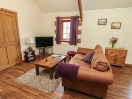 A living room with a sofa and television at Lavender Cottage Caeathro near Caernarfon
