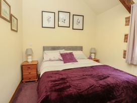 A bedroom with a bed and bedside tables at Lavender Cottage Caeathro near Caernarfon