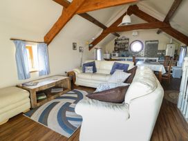A living room with a sofa and table at Bluebell Cottage in Caeathro near Caernarfon
