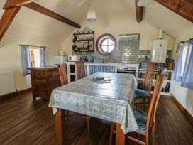 A kitchen with a table and chairs at Bluebell Cottage in Caeathro near Caernarfon