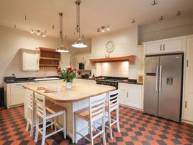 A kitchen with an island and stools at The Lodge in Snainton near Scarborough