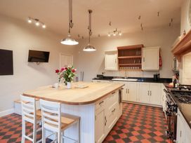 A kitchen with an island and stools at The Lodge in Snainton near Scarborough