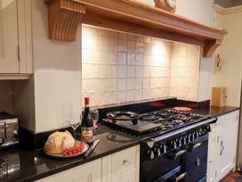 A kitchen with a black granite countertop and a stove at The Lodge in Snainton near Scarborough