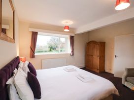 A bedroom with a bed and window at The Lodge in Snainton near Scarborough