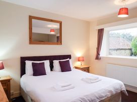 A bedroom with a bed and lamps at The Lodge in Snainton near Scarborough