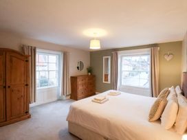 A bedroom with a bed and dresser at The Lodge in Snainton near Scarborough