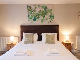 A bedroom with a bed, nightstands, lamps and wall art at The Lodge in Snainton near Scarborough