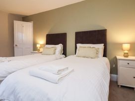 A bedroom with two beds and a nightstand at The Lodge in Snainton near Scarborough