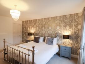 A bedroom with a bed and nightstand at The Lodge in Snainton near Scarborough