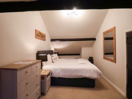 A bedroom with a bed, dresser, and mirror at The Lodge in Snainton near Scarborough