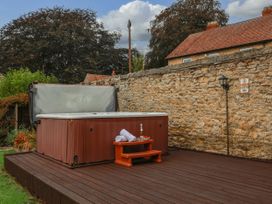 A jacuzzi on a wooden deck with towels and a table at The Lodge in Snainton near Scarborough