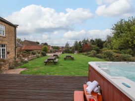 An outdoor area with a hot tub and picnic tables at The Lodge in Snainton near Scarborough