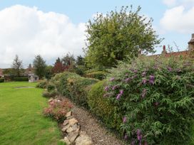 A garden with grass, tree, bushes, and a garden shed at The Lodge Snainton near Scarborough