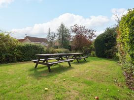 A garden with a picnic table and trees at The Lodge in Snainton near Scarborough