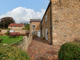 An outdoor area with a brick pathway and seating at The Lodge in Snainton near Scarborough