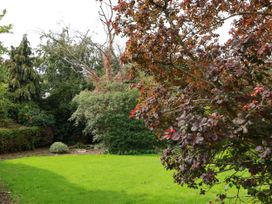 A garden with grass and trees at The Lodge in Snainton near Scarborough