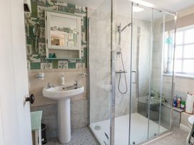 A bathroom with a pedestal sink and a glass-enclosed shower at Peggotty's in Kelsale near Saxmundham