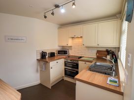 A kitchen with cabinets, sink, stove, and appliances at Back Cottage in Kirkby Lonsdale