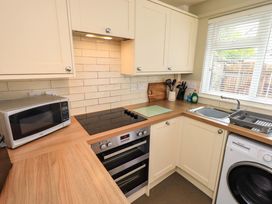 A kitchen with a stove, sink, and appliances at Back Cottage in Kirkby Lonsdale