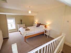 A bedroom with a bed and nightstands at Back Cottage in Kirkby Lonsdale