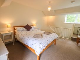 A bedroom with a bed and nightstand at Back Cottage in Kirkby Lonsdale