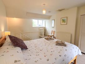 A bedroom with a bed and a chair at Back Cottage in Kirkby Lonsdale