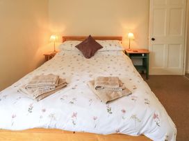 A bedroom with a bed and towels on top at Back Cottage in Kirkby Lonsdale