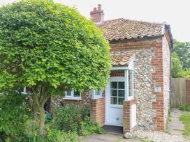 A cottage exterior with a tree and a pathway at Broom Cottage in East Rudham near Fakenham