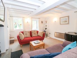 A living room with a red sofa and coffee table at Broom Cottage in East Rudham near Fakenham