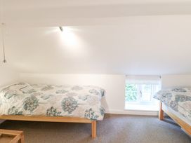 A bedroom with two beds and a window at Broom Cottage East Rudham near Fakenham