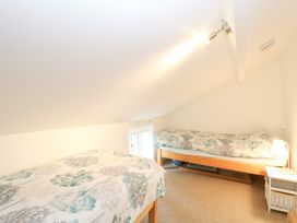A bedroom with two beds and a window at Broom Cottage in East Rudham near Fakenham