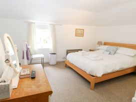 A bedroom with a bed and mirror at Broom Cottage East Rudham near Fakenham