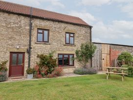 A stone house with a garden and picnic table at Wethercote Cottage Old Byland near Helmsley