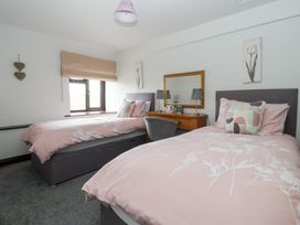 A bedroom with two beds and a desk at Wethercote Cottage Old Byland near Helmsley