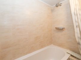 A bathroom with a bathtub and shower fixtures at Wethercote Cottage Old Byland near Helmsley